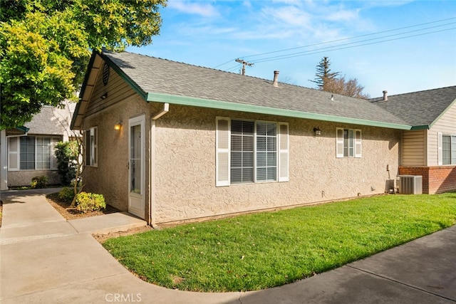 view of side of property featuring a yard and central air condition unit