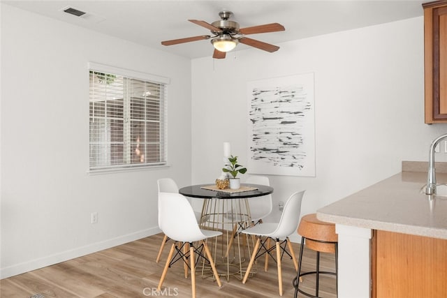 dining space featuring ceiling fan, sink, and light hardwood / wood-style floors