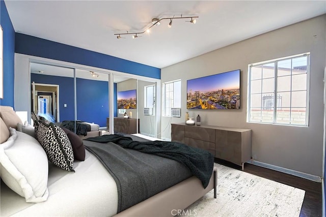 bedroom with dark wood-type flooring and track lighting