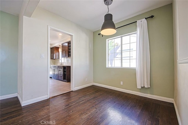 unfurnished dining area with sink and wood-type flooring