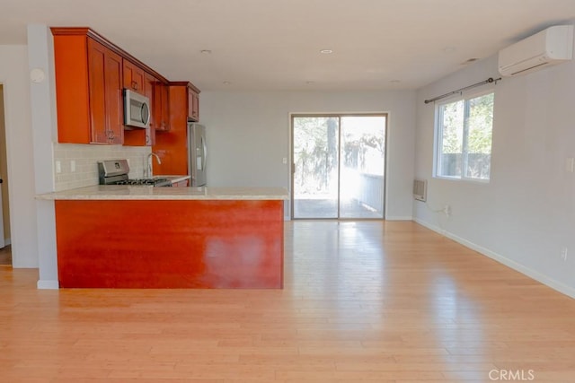 18686 Marine View Rd, Hidden Valley Lake, CA 95467 - kitchen with light wood-style floors, brown cabinetry, light countertops, an AC wall unit, and stainless steel appliances