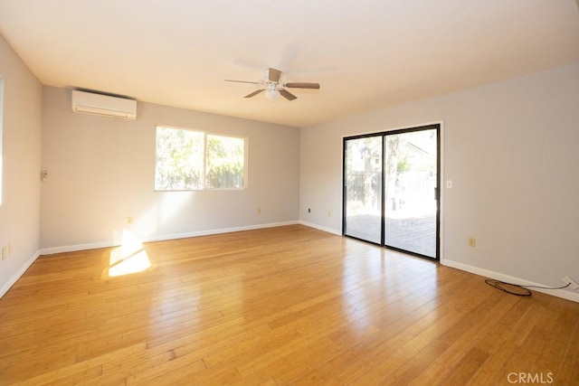 spare room with ceiling fan, a wall mounted air conditioner, and light hardwood / wood-style floors