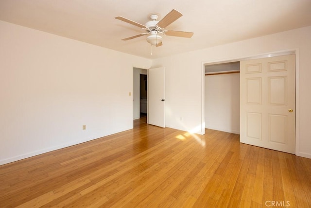 unfurnished bedroom featuring hardwood / wood-style flooring, ceiling fan, and a closet