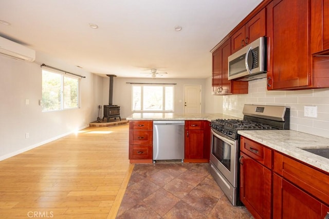 18686 Marine View Rd, Hidden Valley Lake, CA 95467 - kitchen featuring a peninsula, open floor plan, a wealth of natural light, a wood stove, and appliances with stainless steel finishes