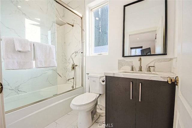 full bathroom featuring vanity, combined bath / shower with glass door, and toilet