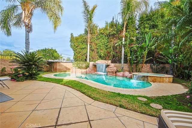 view of swimming pool with a patio, pool water feature, and an in ground hot tub