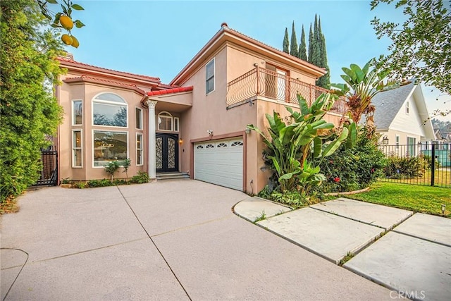 mediterranean / spanish house featuring a garage, french doors, and a balcony