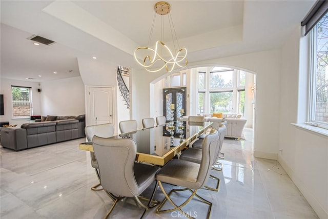 dining space featuring french doors, a chandelier, and a tray ceiling