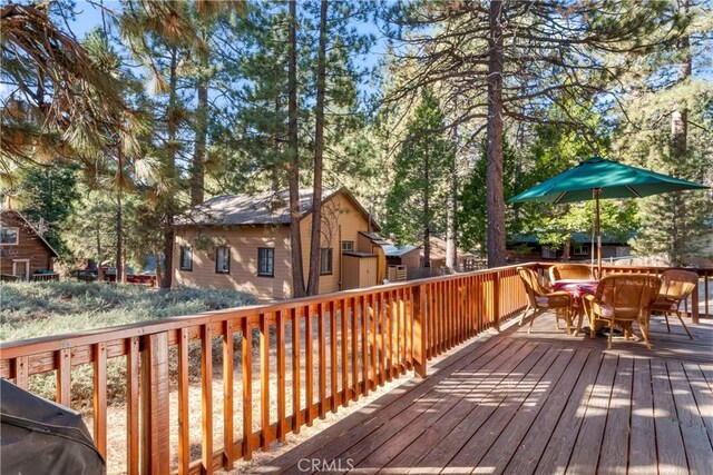 wooden deck featuring a grill and outdoor dining space