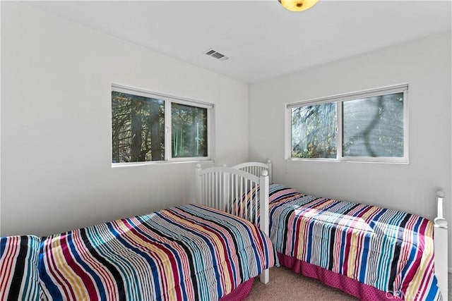 carpeted bedroom featuring visible vents