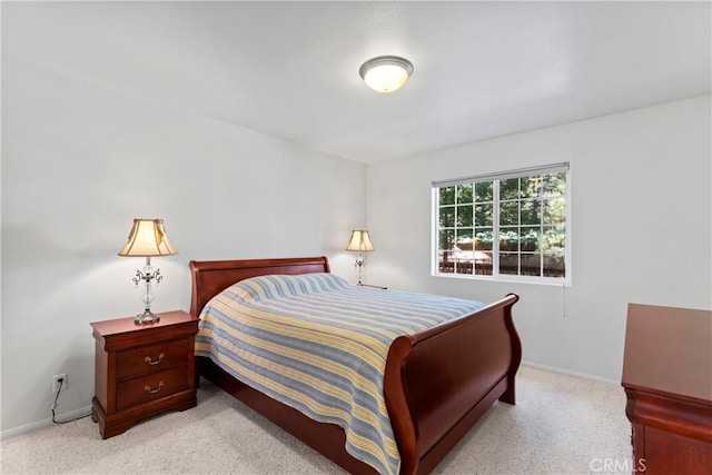 bedroom featuring light colored carpet and baseboards