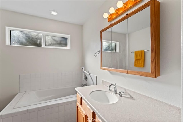 bathroom featuring a garden tub and vanity