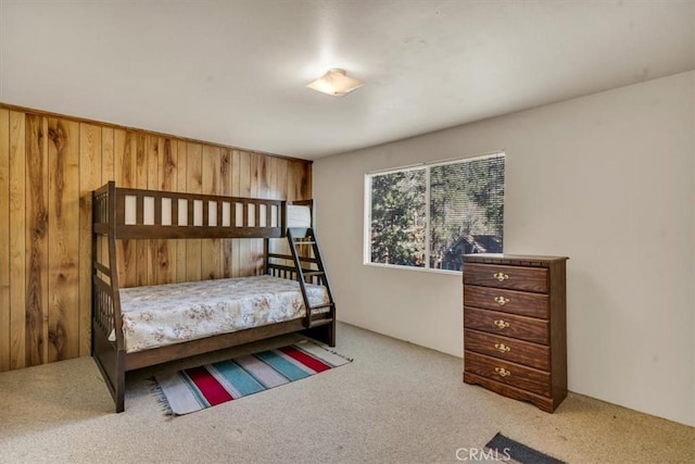 carpeted bedroom with wooden walls