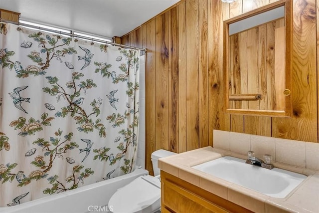 full bathroom featuring vanity, wooden walls, toilet, and shower / bath combo with shower curtain