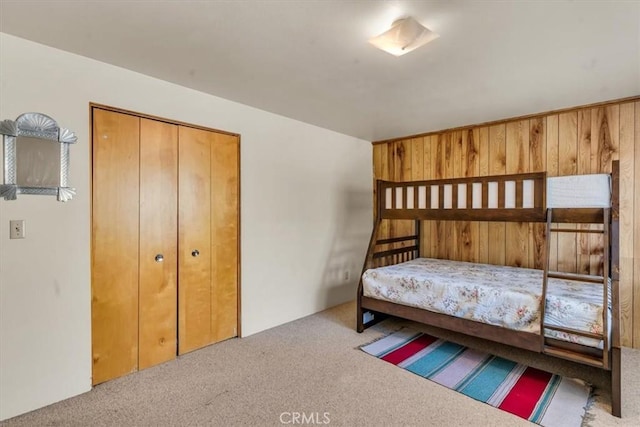 bedroom featuring a closet, carpet floors, and wooden walls