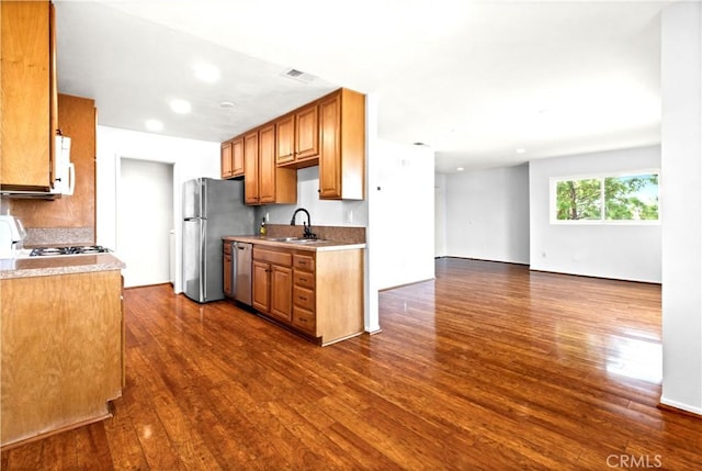 kitchen featuring dark wood-style floors, light countertops, a sink, and stainless steel appliances