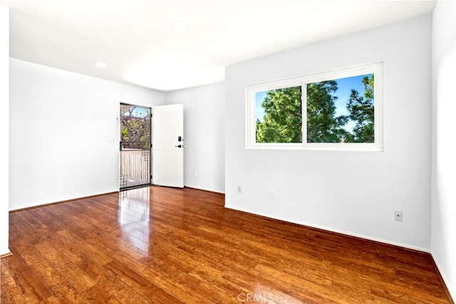 empty room with baseboards and wood finished floors