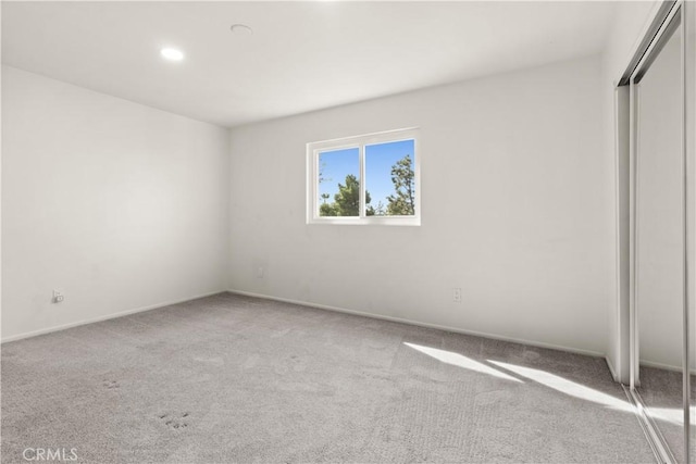 unfurnished bedroom with carpet, baseboards, and a closet