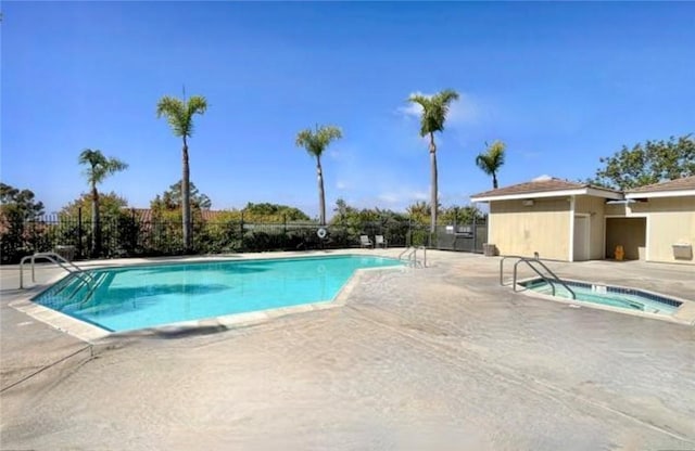 community pool featuring a community hot tub, fence, and a patio