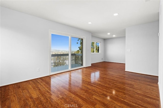 empty room with wood finished floors and recessed lighting