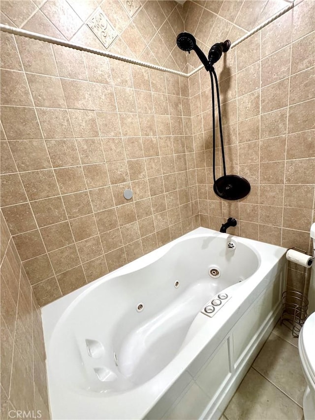 full bath featuring a combined bath / shower with jetted tub, toilet, and tile patterned floors