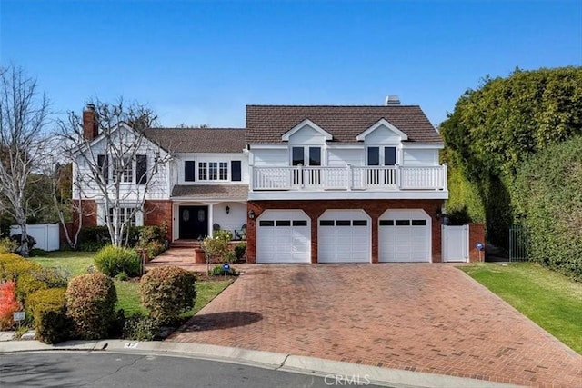 view of front of house featuring a garage, a balcony, and a front yard