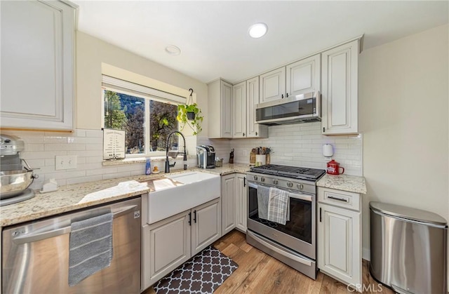 36763 Venado Dr, Coarsegold, CA 93614 - kitchen with stainless steel appliances, light wood-style flooring, tasteful backsplash, light stone counters, and recessed lighting