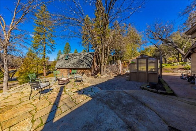 36763 Venado Dr, Coarsegold, CA 93614 - view of yard featuring a fire pit, an outdoor structure, an exterior structure, and a patio