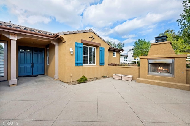 exterior space featuring an outdoor fireplace