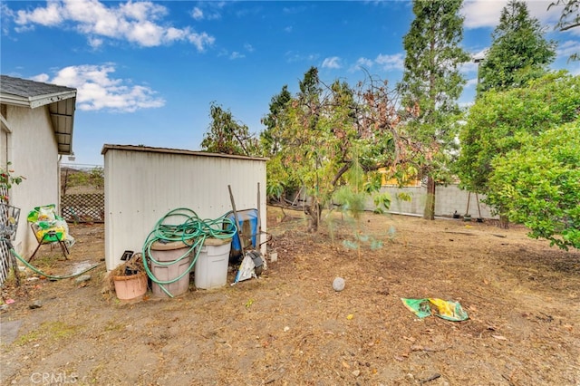 view of yard featuring fence and an outdoor structure