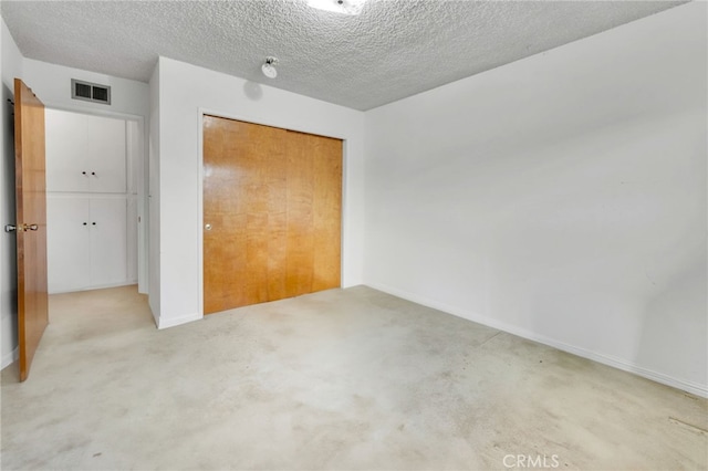 unfurnished bedroom featuring carpet, visible vents, a textured ceiling, and baseboards