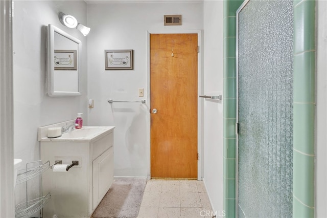 bathroom featuring visible vents, a shower with door, and vanity