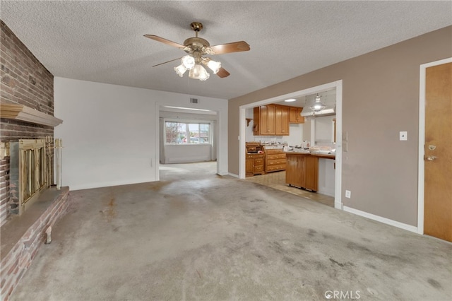 unfurnished living room with light carpet, a textured ceiling, and a brick fireplace