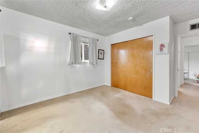 interior space with visible vents, a textured ceiling, and baseboards