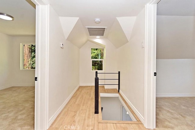 bonus room with lofted ceiling, a healthy amount of sunlight, and light carpet