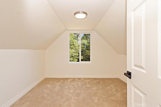 bonus room featuring lofted ceiling and light carpet