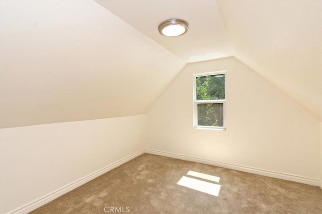 additional living space with lofted ceiling and light carpet