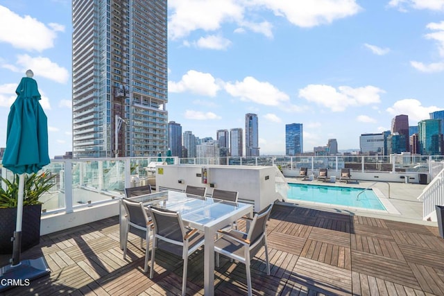 wooden terrace with a community pool and a patio