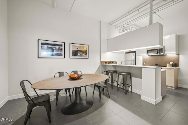 tiled dining space featuring a high ceiling