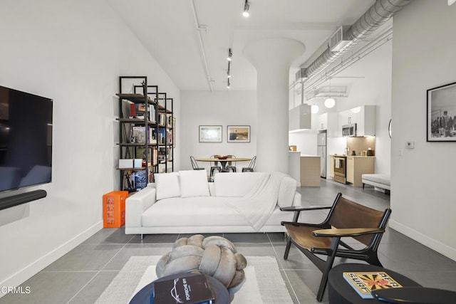 tiled living room with a high ceiling and rail lighting