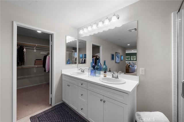 full bathroom featuring double vanity, a spacious closet, visible vents, and a sink