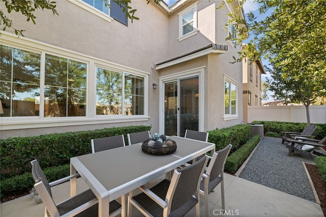 view of patio featuring outdoor dining space and fence