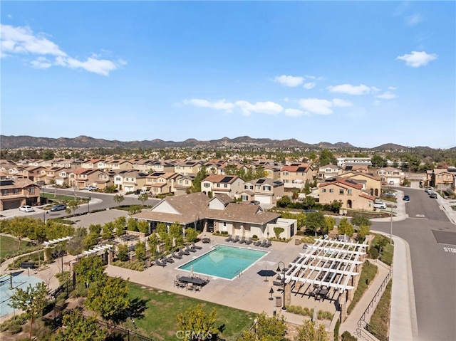 community pool with a patio area, a residential view, and a mountain view