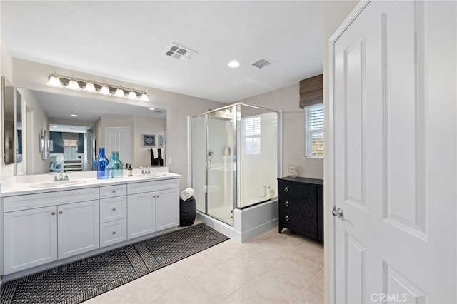 full bath with visible vents, a sink, and a shower with shower door