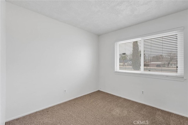 carpeted empty room with a textured ceiling