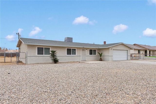 ranch-style home featuring cooling unit and a garage