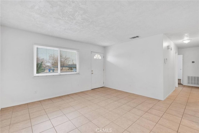 unfurnished room with a textured ceiling