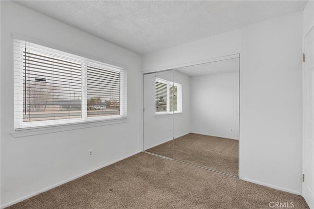 empty room with carpet flooring and a textured ceiling