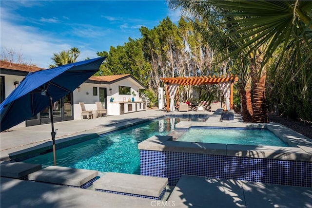 view of swimming pool featuring exterior kitchen, a pergola, and a patio