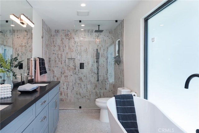 bathroom featuring walk in shower, vanity, toilet, and tile walls